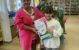 Dziewczynka kt&oacute;ra zajęła drugie miejsce w konkursie stoi z Panią bibliotekarką trzymając sw&oacute;j dyplom.
