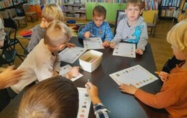 Przy stole siedzą chłopcy i robią jesienne karty pracy.