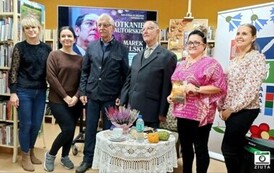 Pan Marek stoi z czytelnikiem i pracownikami biblioteki przy okrągłym stoliku.