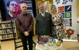 Pan Marek stoi z dwoma czytelnikami przy okrągłym stoliku.