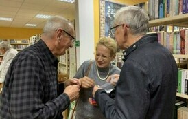 Trzech czytelnik&oacute;w rozmawia ze sobą śmiejąc się.