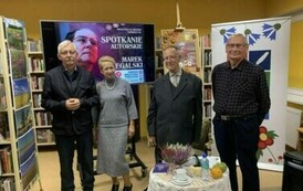 Trzech czytelnik&oacute;w stoi razem z Panem Markiem przy stoliku.