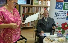 Kierowniczka biblioteki wita Pana Biegalskiego i czyta informacje o poecie. Pan Marek siedzi przy stoliku trzymając swoje utwory.