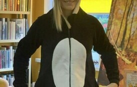 Stoi Pani przebrana za białoczarnego misia i się uśmiecha.