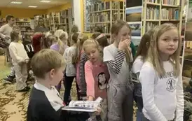 Dzieci stoją w kolejce do pisarki po zakup książki i autograf.