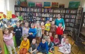 Grupa dzieci przy choince z Panią bibliotekarką.