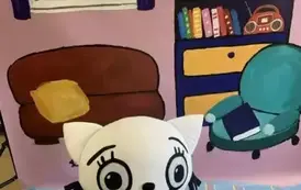 Na tle bajkowego pokoju na dywaniku stoi pluszowa Kicia Kocia