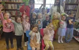 Dzieci stoją w grupie razem z Panią wychowawczynią i z Panią prowadzącą i trzymają w ręku zrobione z papieru marchewki