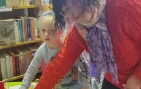 Pani prowadząca i dziewczynka w blond włosach mają położone palce na rysunku ozdobionym stempelkami z marchewek.