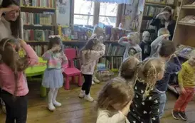 Dzieci ze swoją Panią mają położone rączki nad oczami w geście poszukiwania marchewek w zabawie ciepło-zimno.