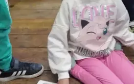 Dziewczynka w blond włosach siedzi na podłodze i ma otwartą książeczkę z r&oacute;żowym kotkiem.