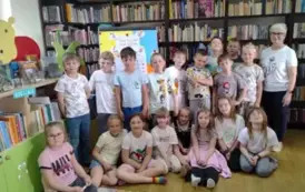 Dzieci stoją w grupie z Panią sołtys Tomaszewa, kt&oacute;ra im gościnnie czytała bajkę.