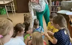 Pani Małgorzata częstuje dzieci cukierkami. 