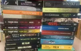 Na stole w dw&oacute;ch rzędach leżą pionowo poukładane nowe książki