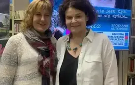 Pisarka stoi ze swoją czytelniczką. Obie Panie się uśmiechają. 