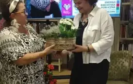 Kierowniczka biblioteki wręcza Annie Sakowicz pudełko z kawiatami i dziękuje za spotkanie.