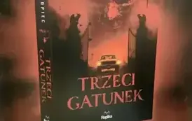 Duży czerwony rolap promujący najnowszą książkę "Trzeci gatunek" i jak i r&oacute;wnież książkę pt "Plon"