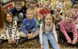 Wszystkie dzieci siedzą razem na dywanie.