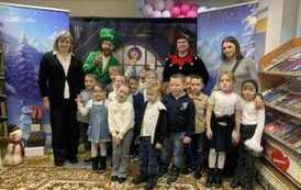 Grupa dzieci stoi z dwoma elfami i dwiema Paniami ze szkoły.