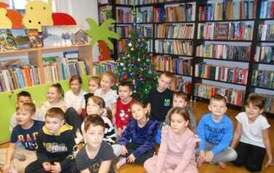 Wszystkie dzieci siedzą przy choince.