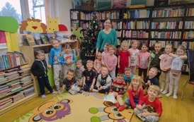 Zdjęcie grupowe dzieci przy choince razem z bibliotekarką.
