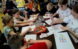 Dzieci siedzą przy stołach i niekt&oacute;re rozwiązują krzyż&oacute;wki,a inne uzupełniają matematyczne igloo kolorując kształty odpowiednim kolorem jaki pokazuje wynik z obliczeń.