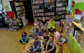 Grupa dzieci siedząca na dywanie.