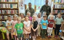 Dw&oacute;ch leśnik&oacute;w stoi w grupie z dziećmi