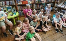 Dzieci siedzą na siedziskach i słuchają bajki