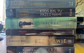 Na stole są wyłożone nowości wydawnicze z widocznymi tytułami