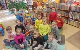Zdjęcie grupowe dzieci i Pani bibliotekarki w bibliotece.