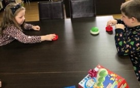 Chłopiec z dziewczynką grają przy stole w hokej stołowy.