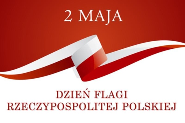 Na białoczerwonym tle napis 2 Maja Dzień Flagi Rzeczypospolitej Polskiej i&nbsp;podwinięta białoczerwona wstążka.