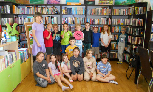 Dzieci stoją w grupie z bibliotekarką