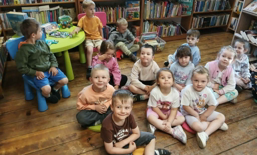 Dzieci siedzą na siedziskach i słuchają bajki