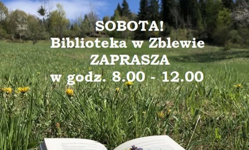 Książka leży na trawie otwarta, a na niej kwiaty. Wyżej informacja o czynnej bibliotece w Zblewie w sobotę w godz.8-12
