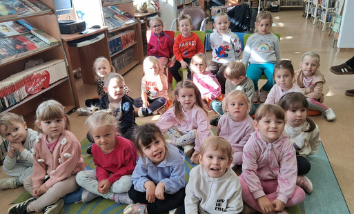Grupa dzieci siedzi na dywanie